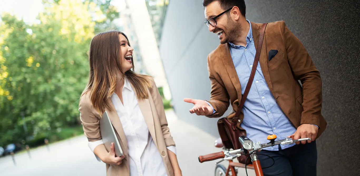 Two people laughing on a city street
